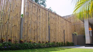 A bamboo fence with a garden in front. - Rusty Seminyak (Seminyak)