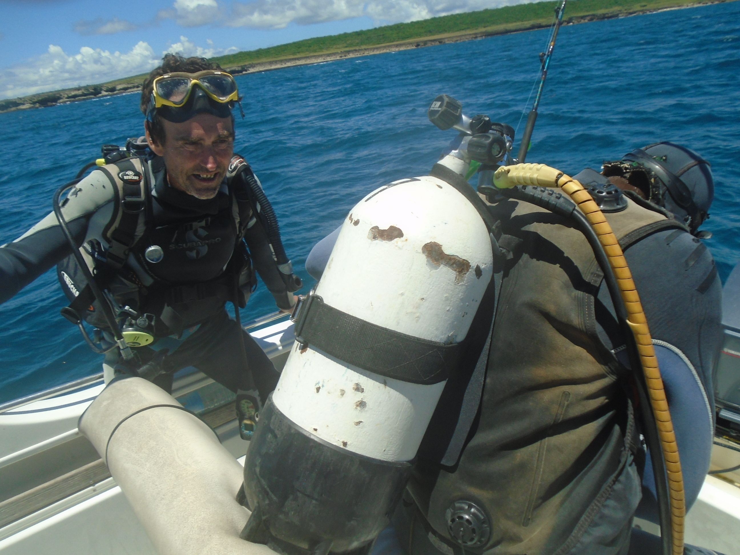 Un buceador en un bote con tanque y equipo de scuba.