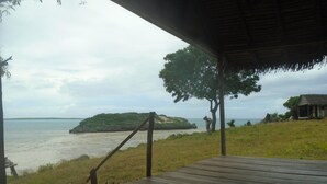 A wooden deck with a view of the sea and a small island. - Emeraude lodge (Antsiranana)
