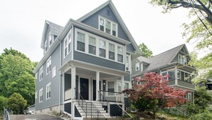 Une maison à deux étages avec un porche à l’avant, un escalier et une allée.