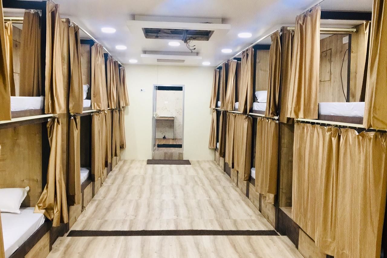 A corridor with bunk beds, wooden walls, and a tiled floor.