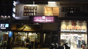 Un bâtiment sur lequel on peut lire les inscriptions « Relax Inn » et « The Men's Studio ».