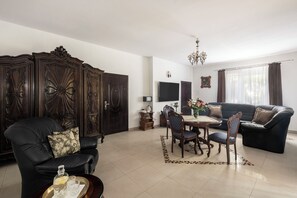 Deluxe Room | Living room | 33-inch flat-screen TV with satellite channels, TV