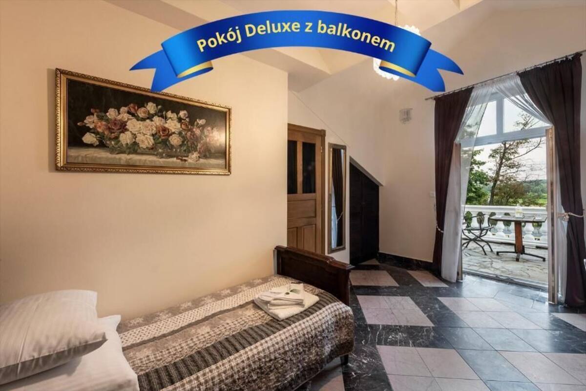 Une chambre à coucher avec un lit, un tableau, une fenêtre et une vue sur l’extérieur.