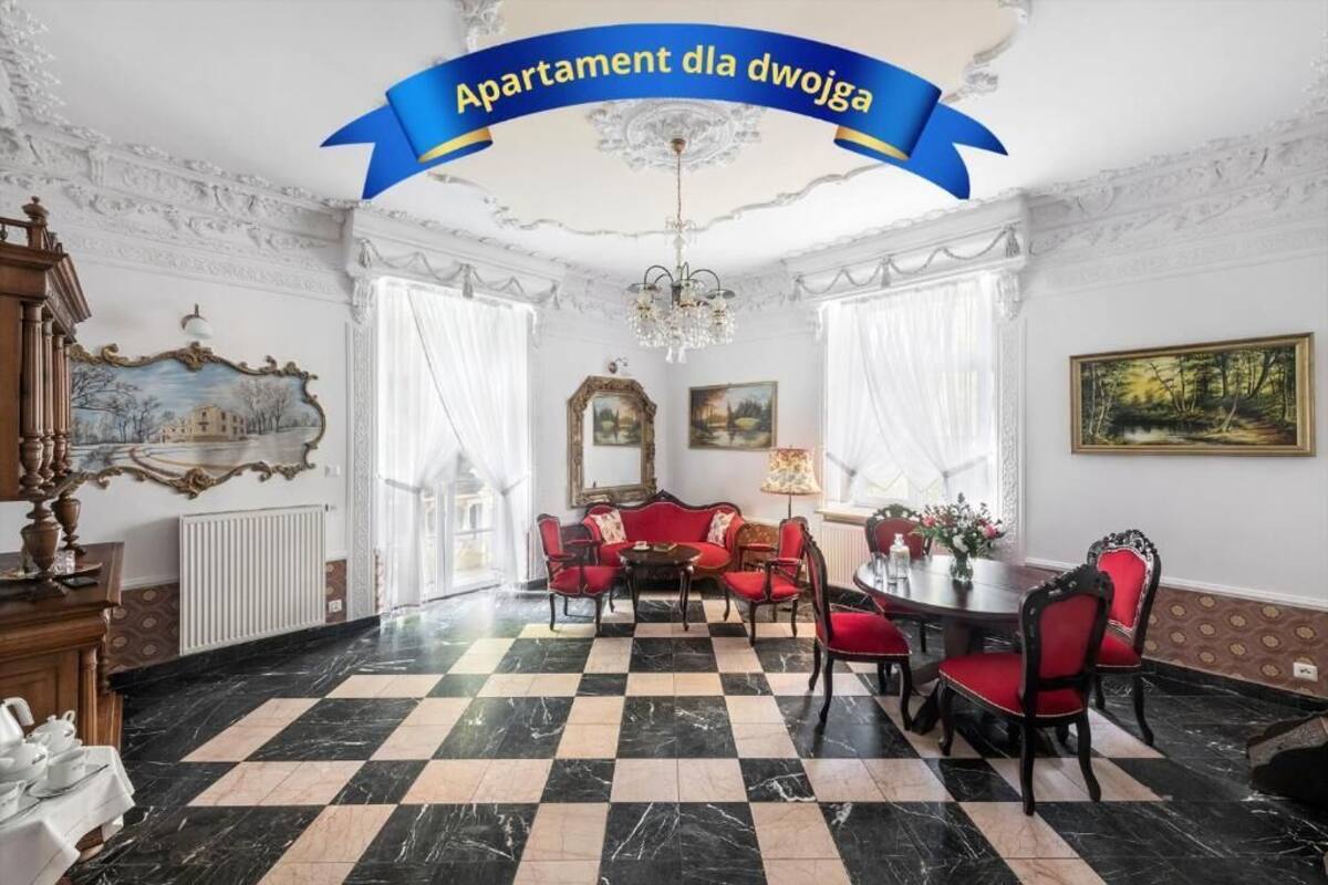 Une pièce spacieuse avec un sol à carreaux, une table à manger avec des chaises, un canapé et un lustre.