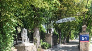Eine Steinstatue eines Löwen am Eingang eines Gebäudes mit der Aufschrift "Palac Tarnowskich".