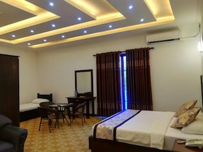 A hotel room with a bed, a desk, a chair, and a small table. - Euro Star Hotel (Seeduwa - Katunayake)