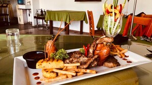 A dining table with a plate of food, a glass of water, and a green tablecloth. - Euro Star Hotel (Seeduwa - Katunayake)