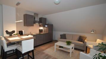 A modern apartment with a kitchen, dining area, and living room.