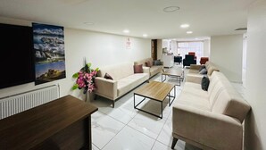 A modern living room with a sofa set, a coffee table, and a TV mounted on the wall. -  Van Toprak Hotel (Van)