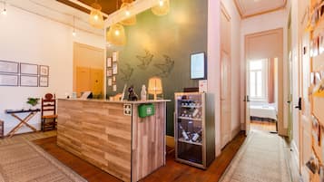 Uma área de recepção com uma mesa de madeira, uma vitrine de vidro e um código QR fixado na parede.