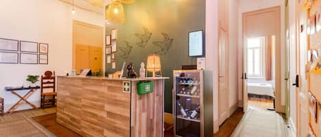 Una zona de recepción con un mostrador de madera, una vitrina de vidrio y un código QR en la pared.