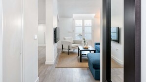 A modern living room with a sofa, a coffee table, and a TV mounted on the wall. - Merced IV - Penthouse apartment in Malaga (Málaga)