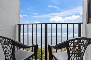 A balcony with a view of the ocean, two chairs, and a railing. - Palace 202 (Myrtle Beach)
