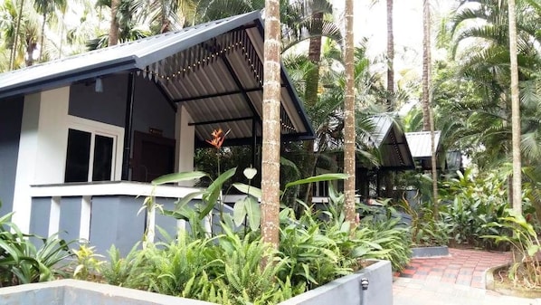 A building with a covered outdoor area, surrounded by lush tropical vegetation.