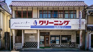 Une auberge de jeunesse avec une enseigne indiquant : « Auberge Marika, située dans la ville fortifiée d’Obi, préfecture de Miyazaki ».