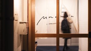 Une personne traverse un passage en passant devant une enseigne sur laquelle on peut lire : « Hôtel Marina, à Castille ».