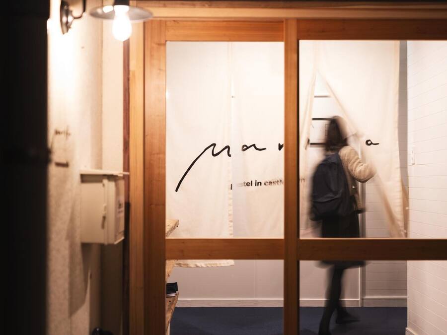 A person walking through a doorway with a sign that reads "Marina Hotel in Castille."