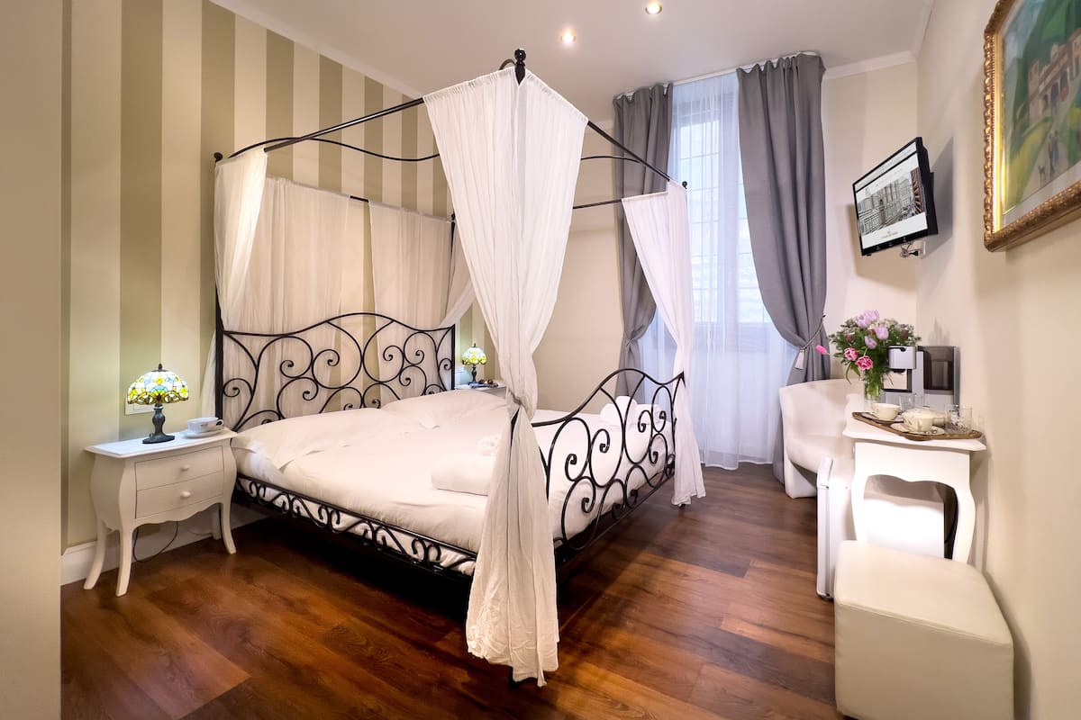 Une chambre à coucher avec un lit à baldaquin, des tables de chevet, un bureau et une chaise.