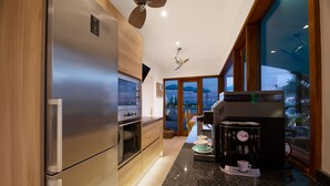 A modern kitchen with stainless steel appliances, a coffee maker, and a view of the outdoors.