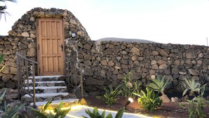 A stone building with a wooden door and steps leading up to it.