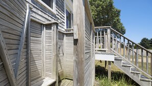 Eine Holzterrasse mit einer Treppe, die zu einem Haus führt.