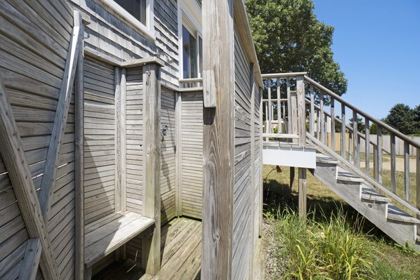 Une terrasse en bois avec un escalier menant à une maison.
