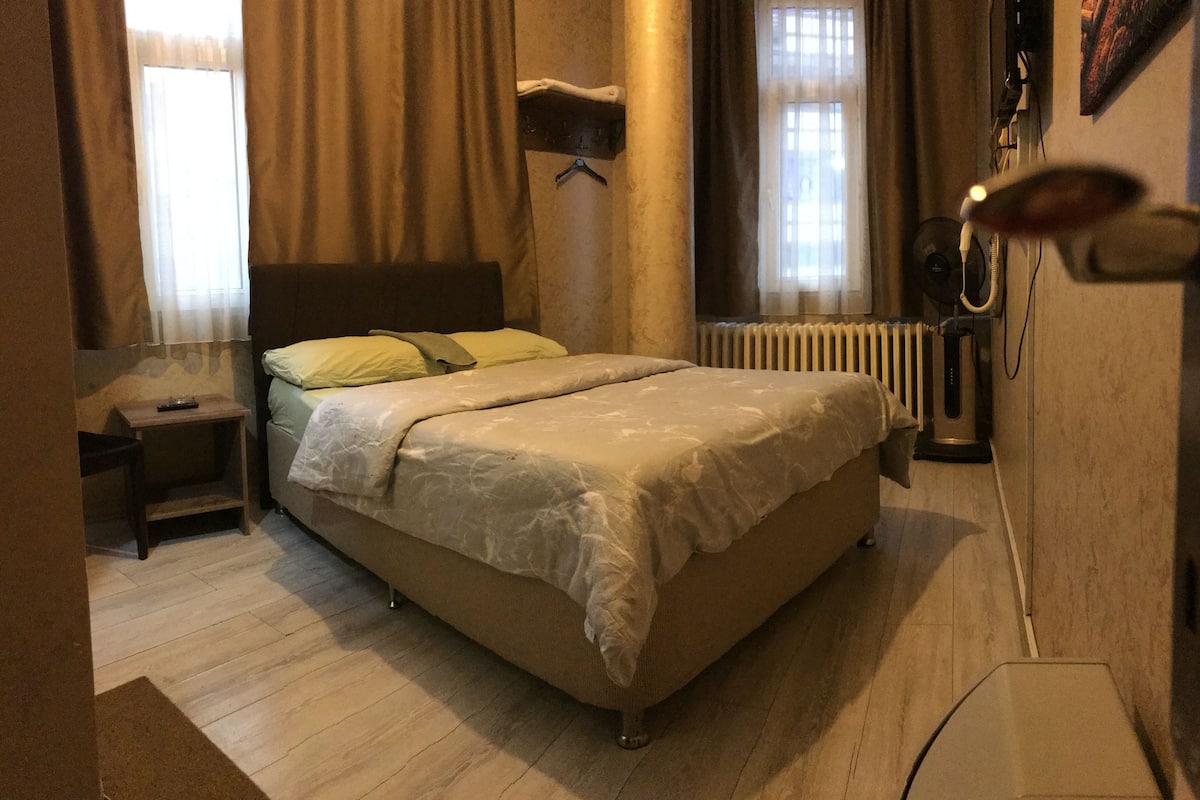 A bedroom with a bed, bedside table, and a radiator.