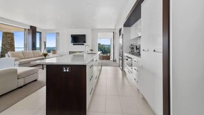 A modern kitchen with a central island, white cabinetry, and a large window offering a view of the outdoors. - Tihi Retreat - Rotorua (Rotorua Township)