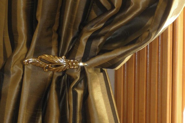 A curtain with a decorative golden tieback. - Spoil yourself at Strupak Cottage, a quiet retreat close to the city (Nelson City)