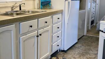 Een koelkast/vriezer, een magnetron, een oven, een kookplaat