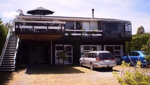 A two-story house with a garage, a staircase, and a car parked in the driveway.