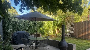 A patio with a table and chairs, a covered grill, and a chimney. - Grand Canyon & Route 66: Historic Williams Getaway (Williams)