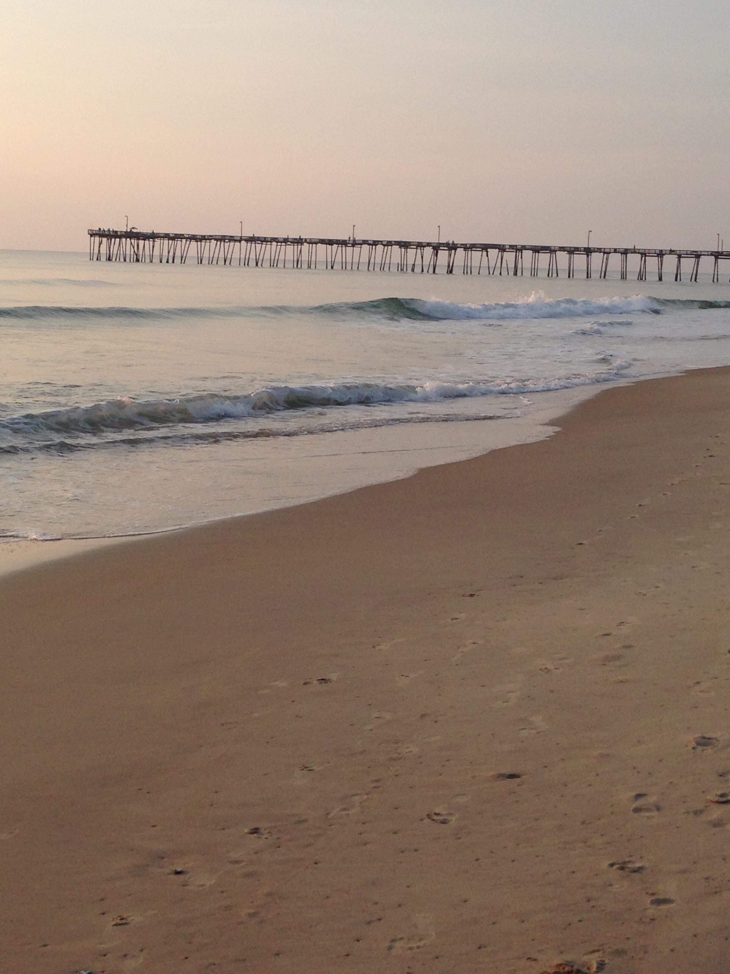 A beach with a pier extending into the water.