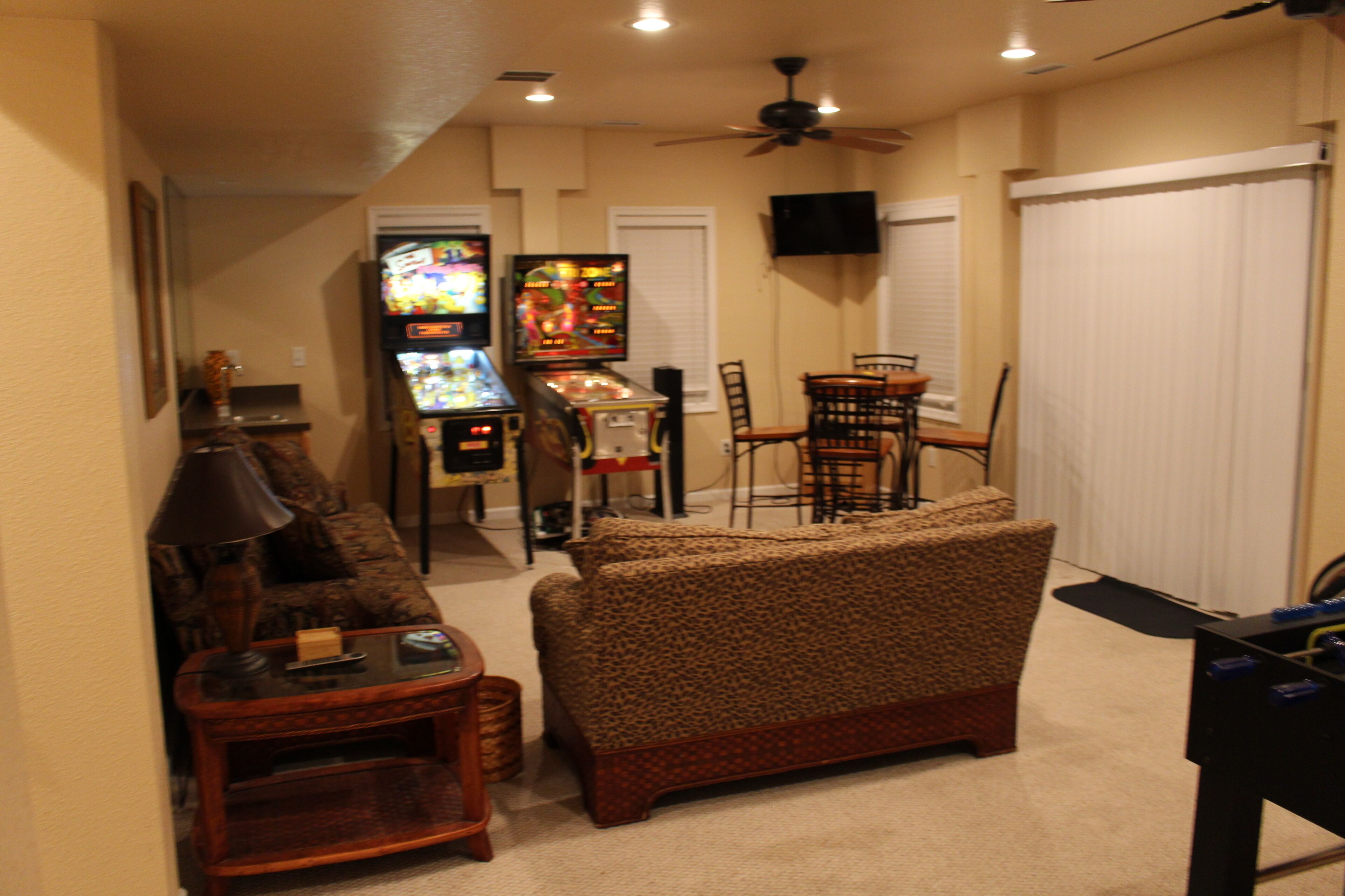 A living room with a sofa, a coffee table, a TV, and a ceiling fan.