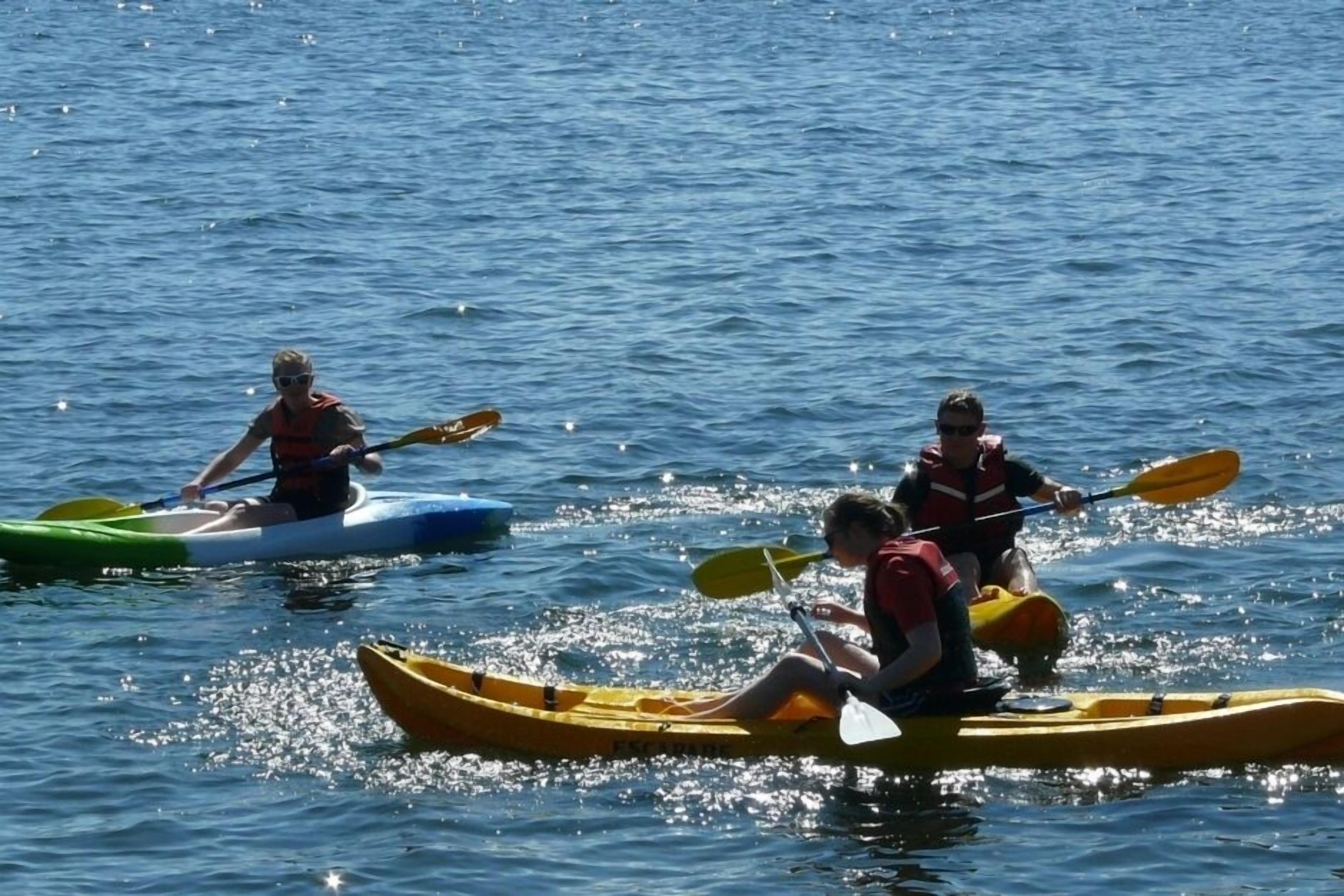 Trois kayaks sur une étendue d’eau calme.