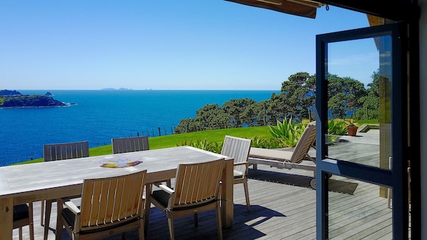 A wooden deck with a table and chairs overlooking a coastal view. - Cliffhouse, Taiharuru, Northland (Whangarei Heads)