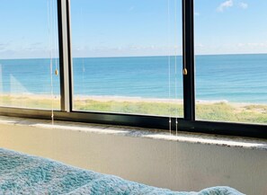 A room with a large window overlooking a beach. - Beautiful Ocean-front Condo with Stunning Views (Fort Pierce)