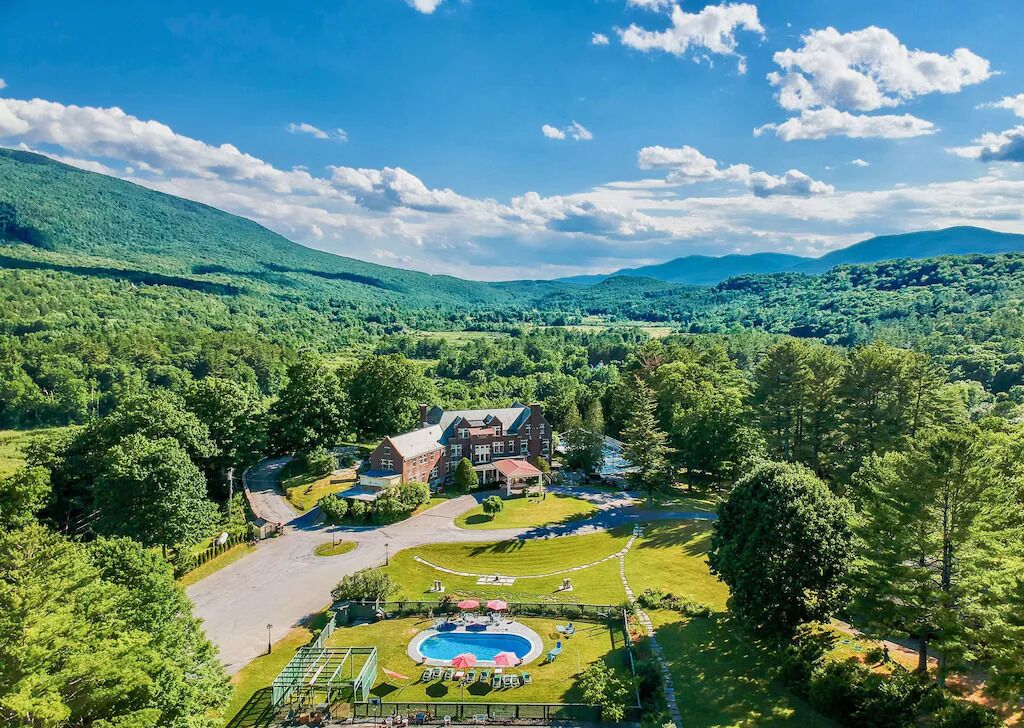 A large estate with a swimming pool, tennis court, and a spacious lawn.