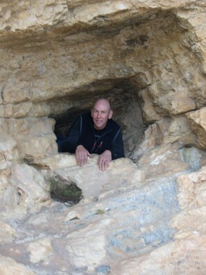 A man in a cave-like structure with rough, uneven walls.
