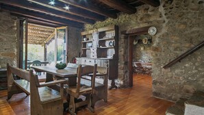 Una cocina rústica con muebles de madera, paredes de piedra y una escalera de madera.