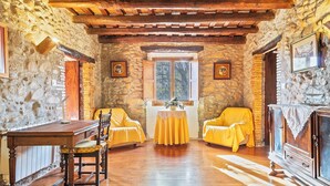 Una habitación rústica con paredes de piedra, muebles de madera y una chimenea.