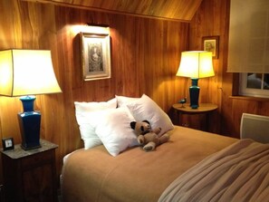 Cozy bedroom with a comfortable bed, bedside lamps, and a framed picture.