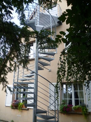 Staircase leads to upper levels, surrounded by lush greenery.