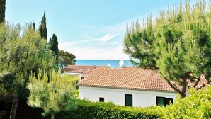 A coastal house with a red-tiled roof, surrounded by pine trees and a clear blue sky. - Pet-friendly vacation home right by the sea - last minute promotion 15% discount (Novigrad)