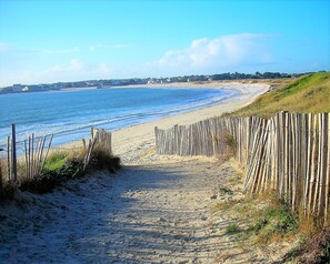 A sandy beach path with a wooden fence leading to the ocean. -   SPLENDID VILLA, SPECTACULAR SEA VIEW. Close to the Beach. (Loctudy)