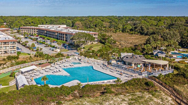 A resort with a large pool, multiple buildings, and a beach area. - Stunning Ocean View from top floor Admirals Row 402  (Hilton Head Island)