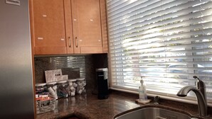 A kitchen with wooden cabinets, a stainless steel sink, and a coffee maker. - High end 1BR/1BA Attached House in the Heart of Silicon Valley, Non-Smokers only (San Jose)