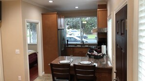 A compact kitchen with a dining area, a refrigerator, a window with a view of the street, and a door leading to another room. - High end 1BR/1BA Attached House in the Heart of Silicon Valley, Non-Smokers only (San Jose)