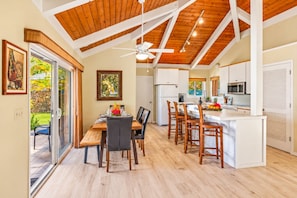 A spacious kitchen with a central island, white cabinetry, and a ceiling fan.